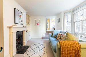 a living room with a blue couch and a fireplace at Cosy Flat in Battersea Park in London