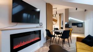 a living room with a fireplace with a tv above it at Apartament na Spokojnej 24J/16 in Wisła