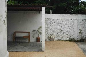 einen Tisch und einen Stuhl unter einer Wand in der Unterkunft Casa yucateca ZAMA en Santiago. in Mérida