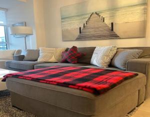 a couch with a plaid blanket on it in a living room at Stunning Stayz At Friday Harbour Beach Marina Resort Lake Simcoe Innisfil in Innisfil