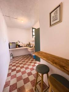 eine Küche mit einem karierten Boden, einer Theke und einem Stuhl in der Unterkunft Casa yucateca ZAMA en Santiago. in Mérida