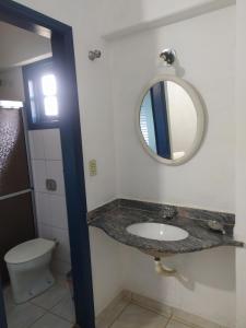 a bathroom with a sink and a mirror at Pousada Sino dos Ventos in São Sebastião do Rio Verde