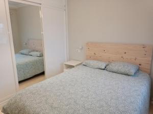een slaapkamer met een bed en een spiegel bij La Azotea de Cristina in Sevilla