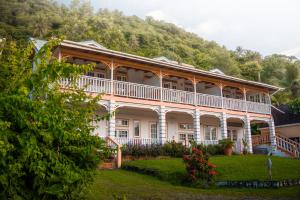 苏弗里耶尔拉浩特度假酒店的一座大白色房子,后面有一座小山