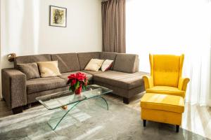 a living room with a couch and a yellow chair at Forest Park Garden Apartment in Bratislava