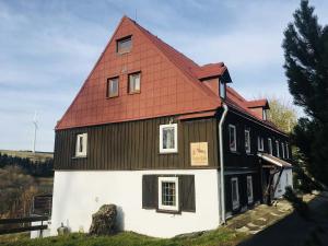 a black and white house with a red roof at Horská bouda Šubišák in Loučná pod Klínovcem