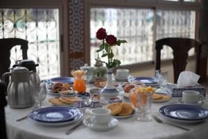 a table with blue plates of food and a rose at Riad La Perle De La Médina in Fez