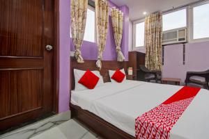 a bedroom with a bed with red pillows at Hotel Rameshwaram in Jaipur