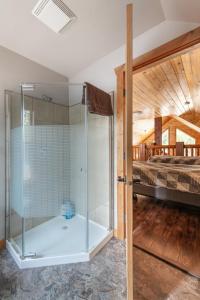 a glass shower in a bedroom with a bed at Cranberry in Valemount