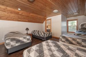 two beds in a room with a wooden ceiling at Cranberry in Valemount