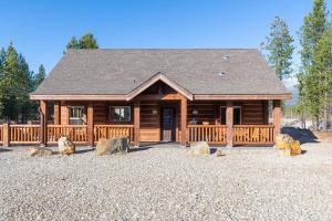 a large log cabin with a porch and some rocks at Cranberry in Valemount