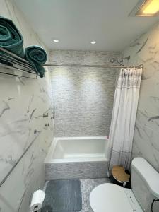 a bathroom with a bath tub and a toilet at The Waltham Private Room & Bathroom JFK LGA 10min I 20min ManhattanPenn Station bullet-train in Queens