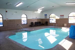 New Victorian Inn & Suites-Norfolk في نورفولك: حمام سباحة بمياه زرقاء في غرفة بها نوافذ