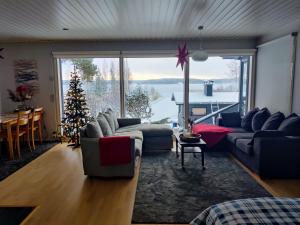 a living room with a christmas tree and a large window at Cottage by the sea in Turku