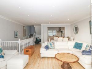 a living room with a white couch and a table at The Beach House in Pwllheli