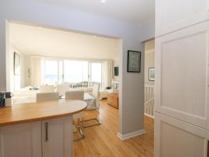 a kitchen and living room with a table at The Beach House in Pwllheli
