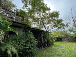 uma casa com um pátio verde ao lado de um edifício em CASA DE CHICO - Tiny House em Guarda do Embaú