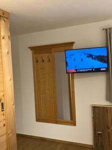 TV de pantalla plana en la pared de una habitación en Haus Berge Appartements, en Wagrain