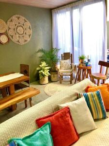 un soggiorno con divano e cuscini colorati di Villa Verde, casa charme a São Miguel dos Milagres Altre 43 foto