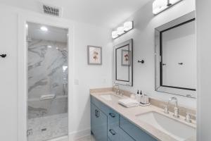 a white bathroom with two sinks and a shower at The Rest at Potomac Farms in Ashburn