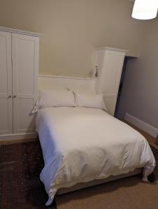 a bedroom with a white bed and a cabinet at La Montagne Observatory in Cape Town