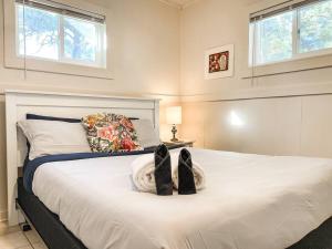 Un dormitorio con una gran cama blanca con zapatos. en Mountain View Duplex / Walk to main street, en Woodland Park