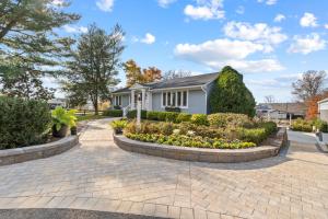 a home with a brick driveway and landscaping at The Rest at Potomac Farms in Ashburn