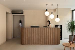 a woman standing behind a reception desk in an office at KYMANI Boutique Hotel & Suites in Plakias