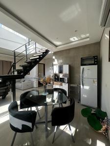 a dining room with a glass table and a spiral staircase at Puerta del Lago in San Bernardino