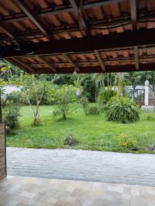 an outside view of a garden with a patio at Apê Aconchegante - 4 pessoas in Bertioga