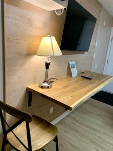 a desk with a lamp and a chair in a room at Harbour Light Motel in Nanaimo