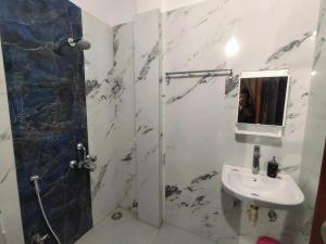 卡修拉荷的住宿－Khajuraho Glory Homestay，一间带水槽、淋浴和镜子的浴室