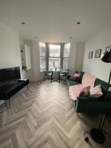 een woonkamer met een groene bank en een tafel bij Stylish Apartments near the sea front at Morecambe in Heysham