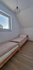 a bedroom with two beds and a window at Domki nad jeziorem u Izy in Kiedrowice