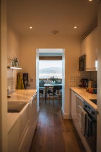 a kitchen with a sink and a dining room with a table at Kinkell Cottage in Dingwall