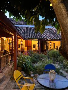 een patio met een tafel en stoelen in een tuin bij CASA SINNING-año1637 in Mompos