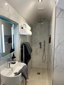 a bathroom with a sink and a shower at The Snug- With Private parking in Whitstable