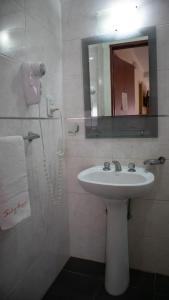 La salle de bains est pourvue d'un lavabo et d'un miroir. dans l'établissement Departamentos Sol y Arena, à San Clemente del Tuyú