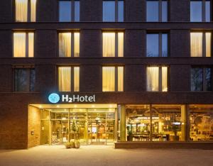 un gran edificio con un cartel de hoteles en él en H2 Hotel Mainz en Mainz
