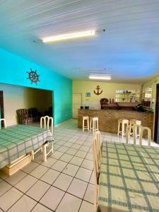 a room with a table and chairs and a kitchen at Pousada Elpirata Sidney in Ceará-Mirim