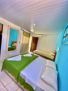 Ceará-MirimにあるPousada Elpirata Sidneyのベッドルーム1室(大型ベッド1台、緑の毛布付)