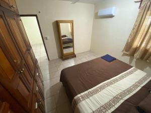 Dormitorio pequeño con cama y espejo en hermosa casa para vacacionar en Puerto Escondido