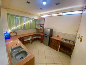 a small kitchen with a sink and a refrigerator at hermosa casa para vacacionar in Puerto Escondido