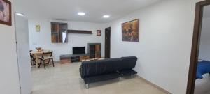 a living room with a black chair and a table at Villa Verde Pet-friendly in Córdoba
