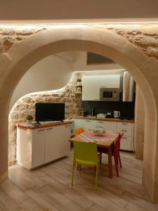 a kitchen and dining room with a table and an archway at Casa vacanze Modica Charme in Modica