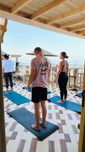 eine Gruppe von Menschen, die in einem Yoga-Kurs stehen in der Unterkunft Surf Break Morocco in Imsouane