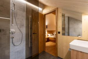 ein Bad mit einer Dusche und einem Waschbecken in der Unterkunft Ferienwohnungen Nigsch in Schoppernau