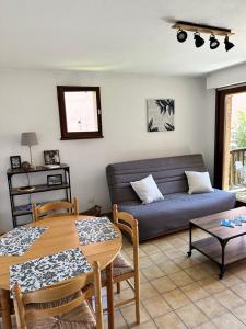 een woonkamer met een bank en een tafel bij Charmant appartement in Briançon