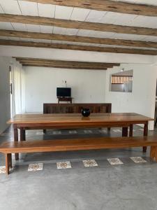 a large wooden table in a room with a couch at Casa Flor da Terra in Caraíva +4 photos