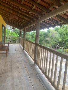 a porch of a house with a wooden deck at Casa Flor da Terra in Caraíva